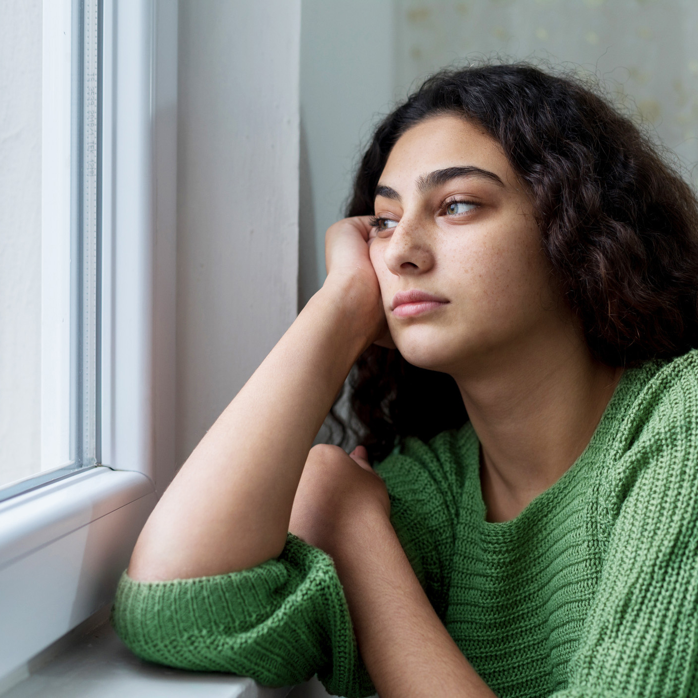 A young woman gazes out a window