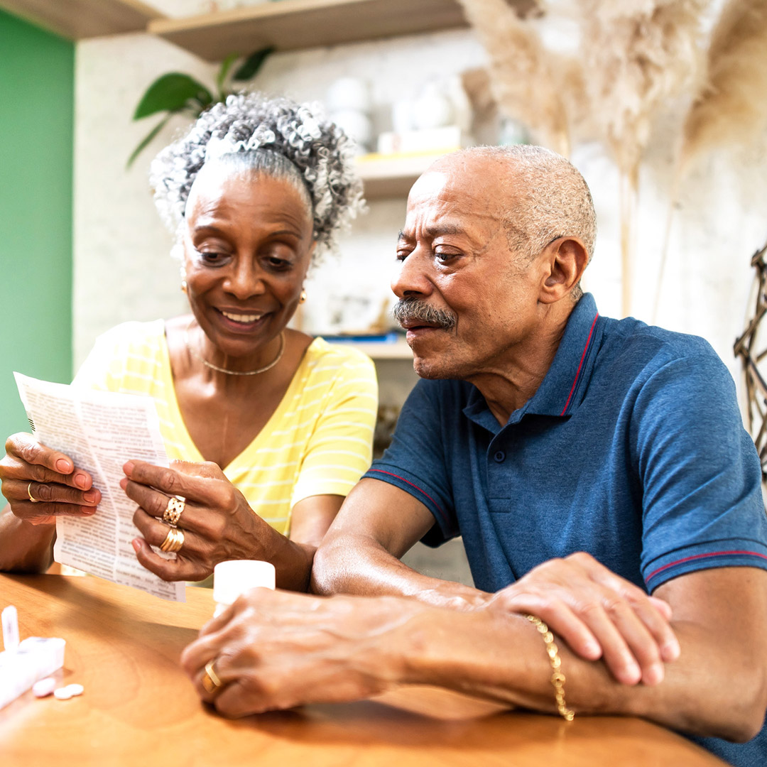 An older couple looks over the information that came with one of their prescription medications.