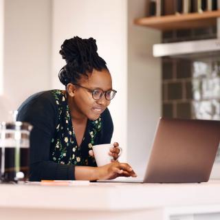 A young woman does research on her prescription medication using her laptop computer.